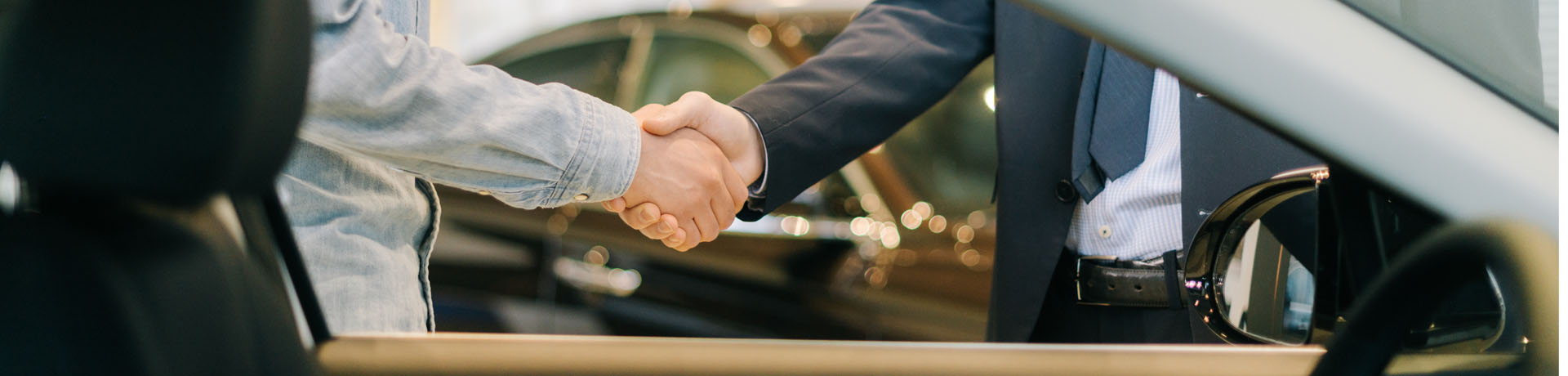 Real Garant sales representative selling a warranty at a car dealership – handshake
