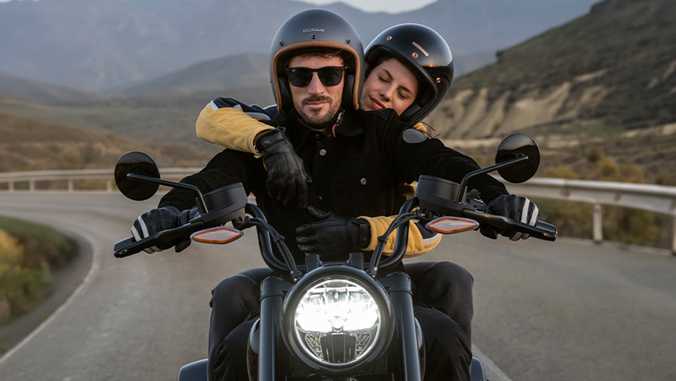 Man rinding a mortcycle with a woman in the back