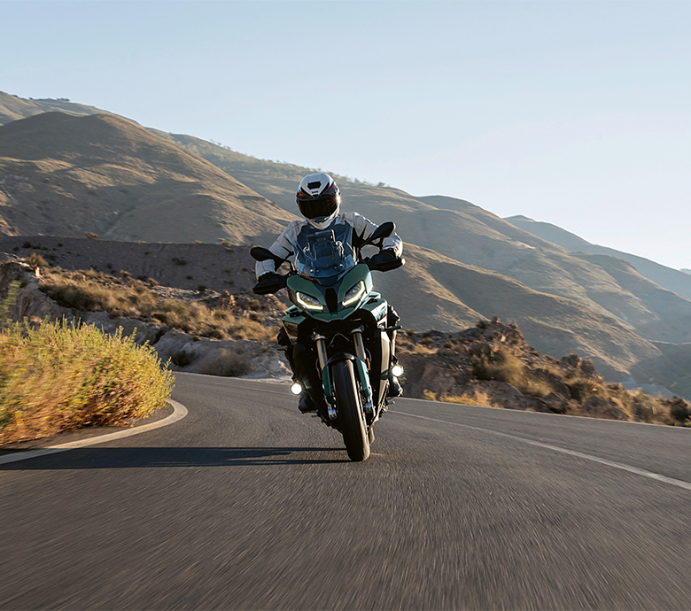 Person riding a BMW motorcycle through the mountains.